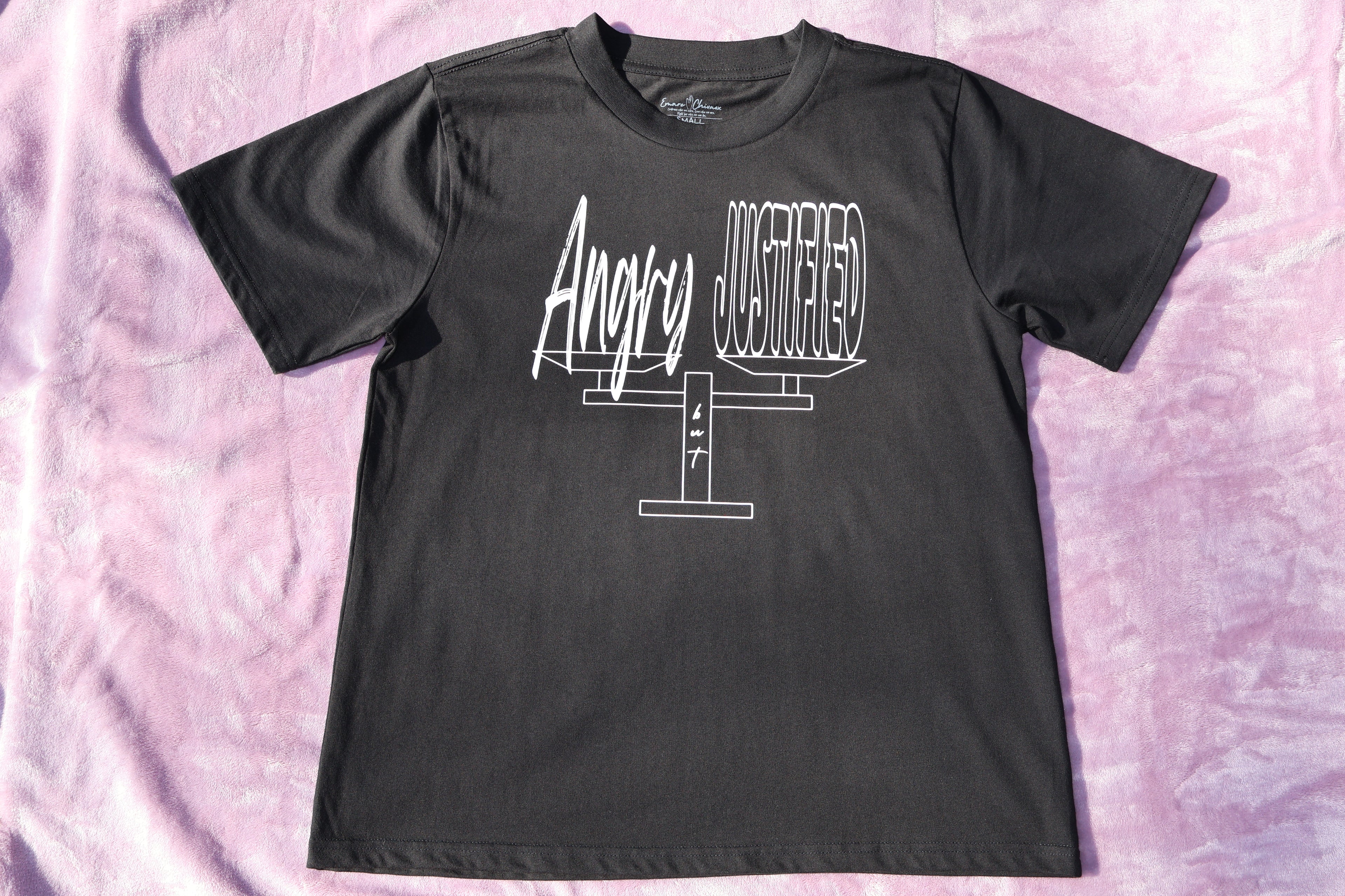 Black t-shirt with white 'Angry but Justified' text and graphic design on a lavender background