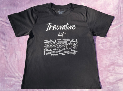 Black t-shirt with white 'Innovative but Appropriated' text and graphic design on a lavender background.