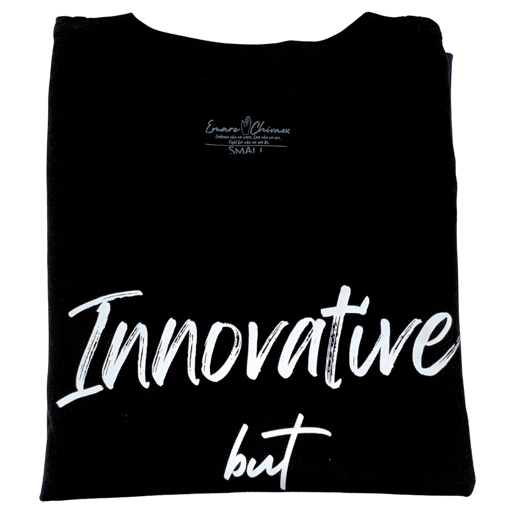 Front of black t-shirt folded with "Innovative but" white text design on a white background