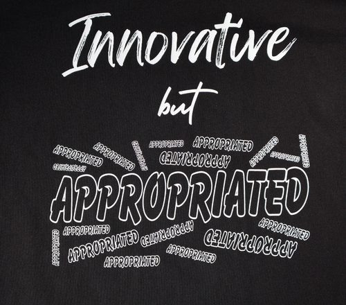 Zoomed in view of black t-shirt with white 'Innovative but Appropriated' graphic design.