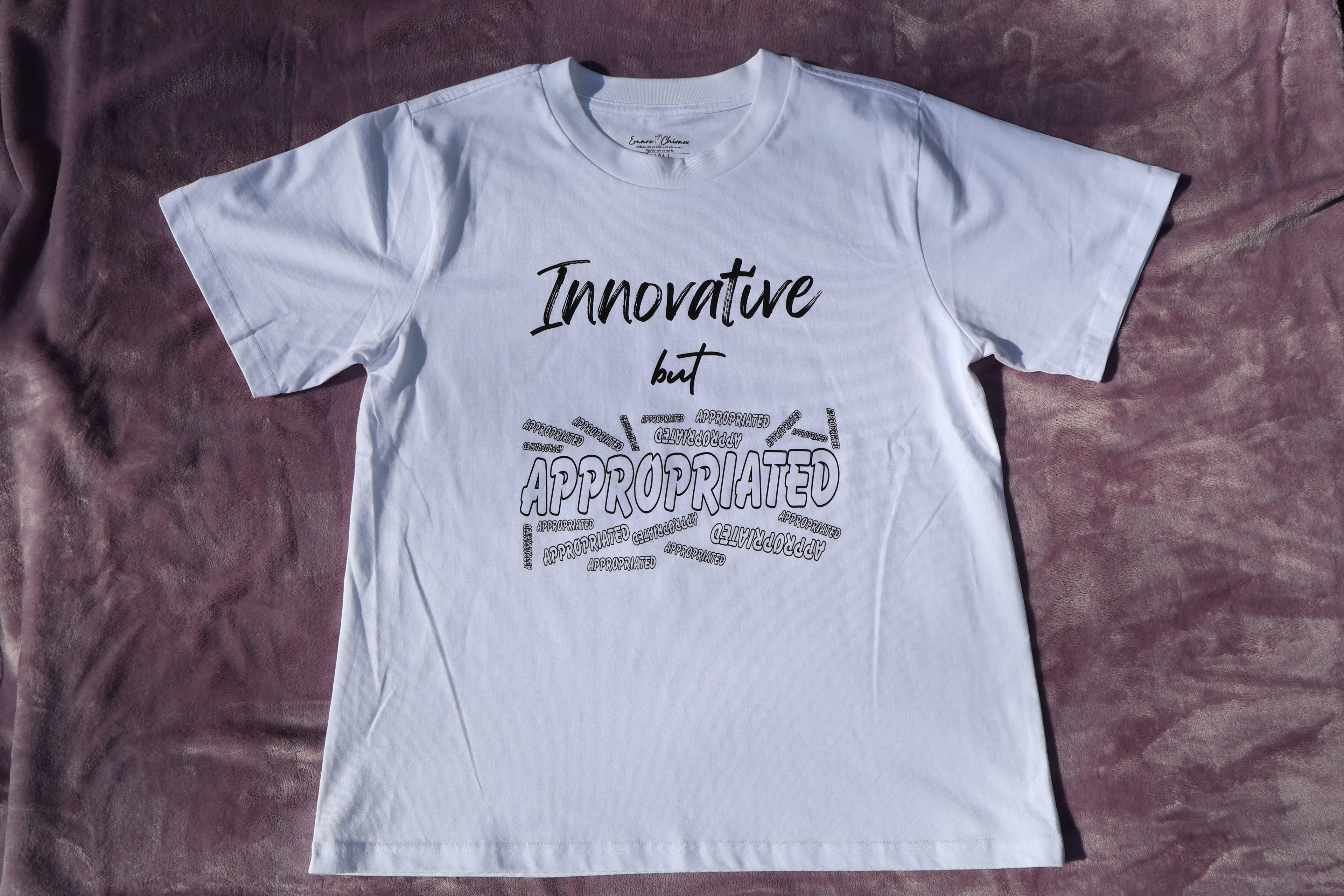 White t-shirt with black 'Innovative but Appropriated' text and graphic design on a lavender background.