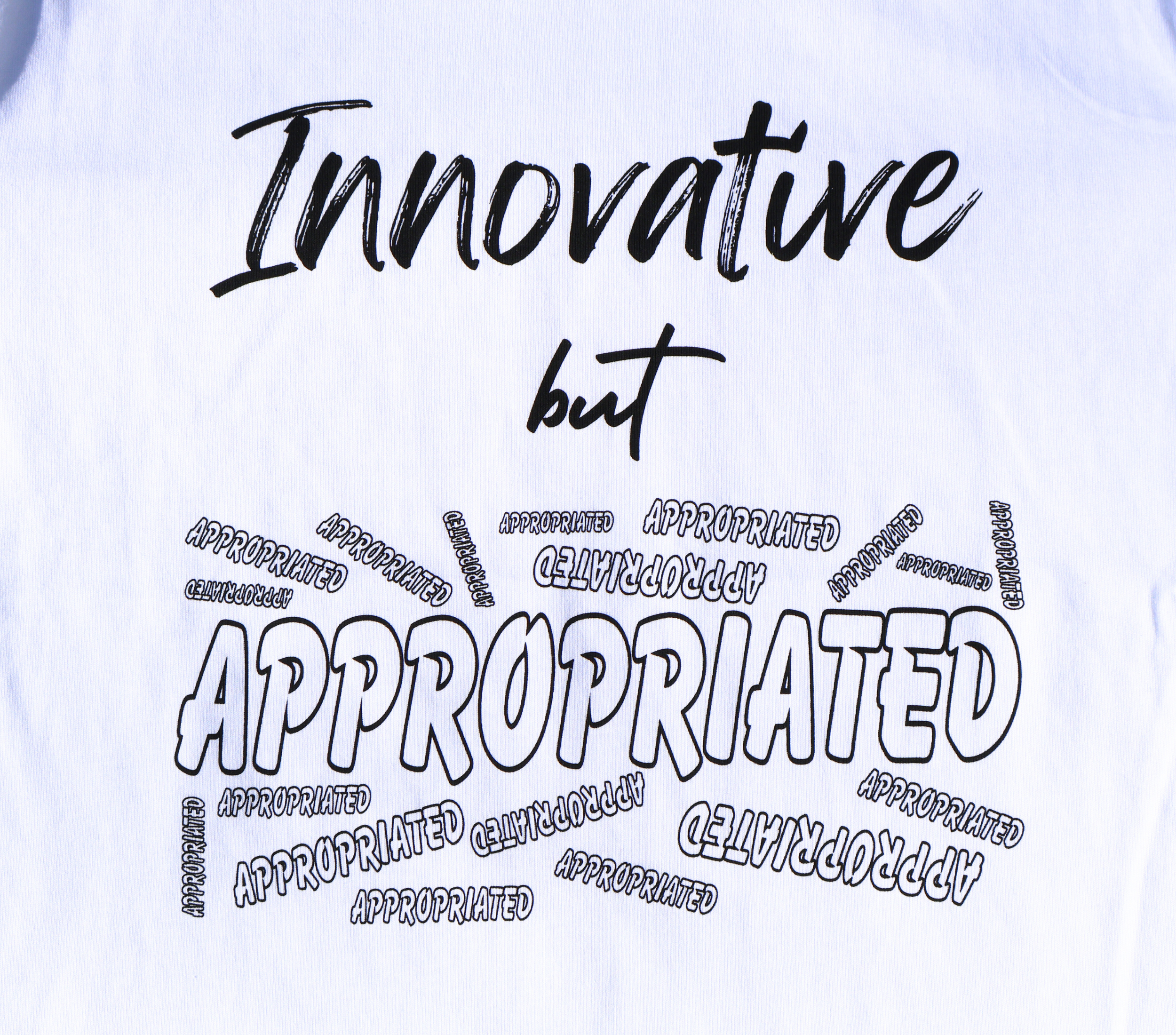 Zoomed in view of white t-shirt with black 'Innovative but Appropriated' graphic design.