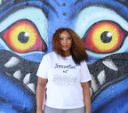Woman wearing a white t-shirt with black 'Innovative but Appropriated' graphic design, standing in front of a colorful mural.