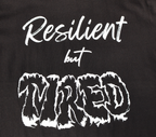 Zoomed in view of black t-shirt with white 'Resilient but Tired' graphic design.