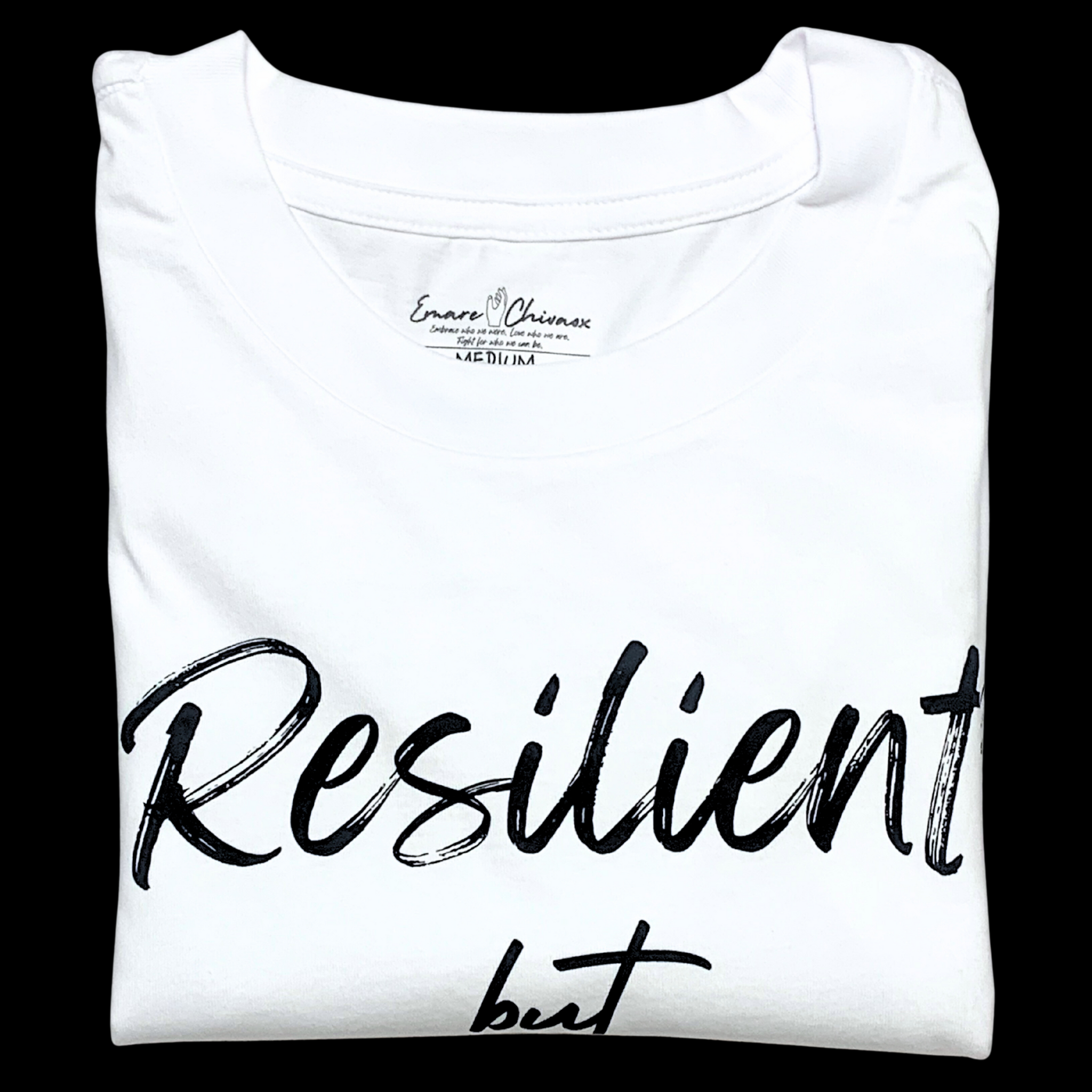 Front of white t-shirt folded with "Resilient but" black text design on a black background