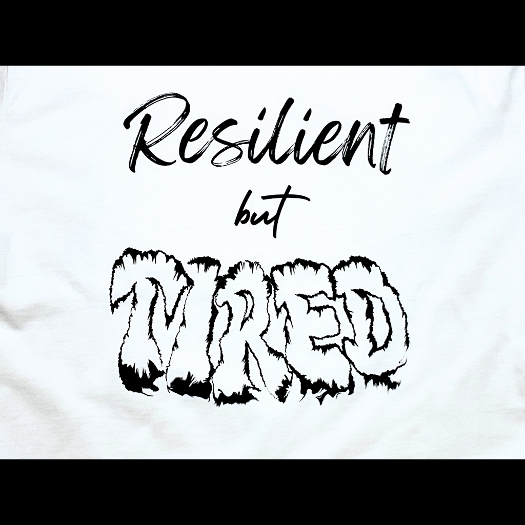 Center of white t-shirt with "Resilient but Tired" black text design on a black background