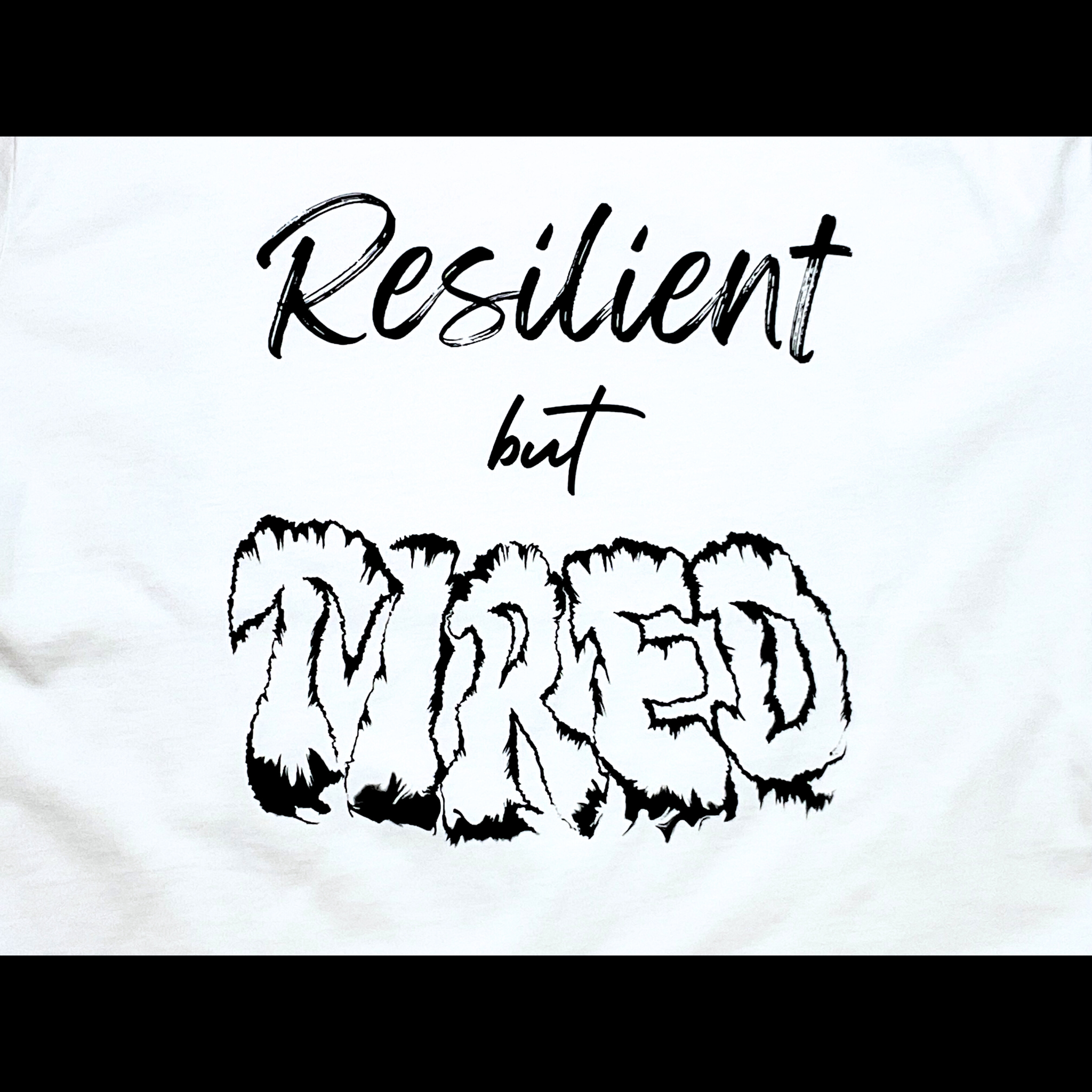 Center of white t-shirt with "Resilient but Tired" black text design on a black background
