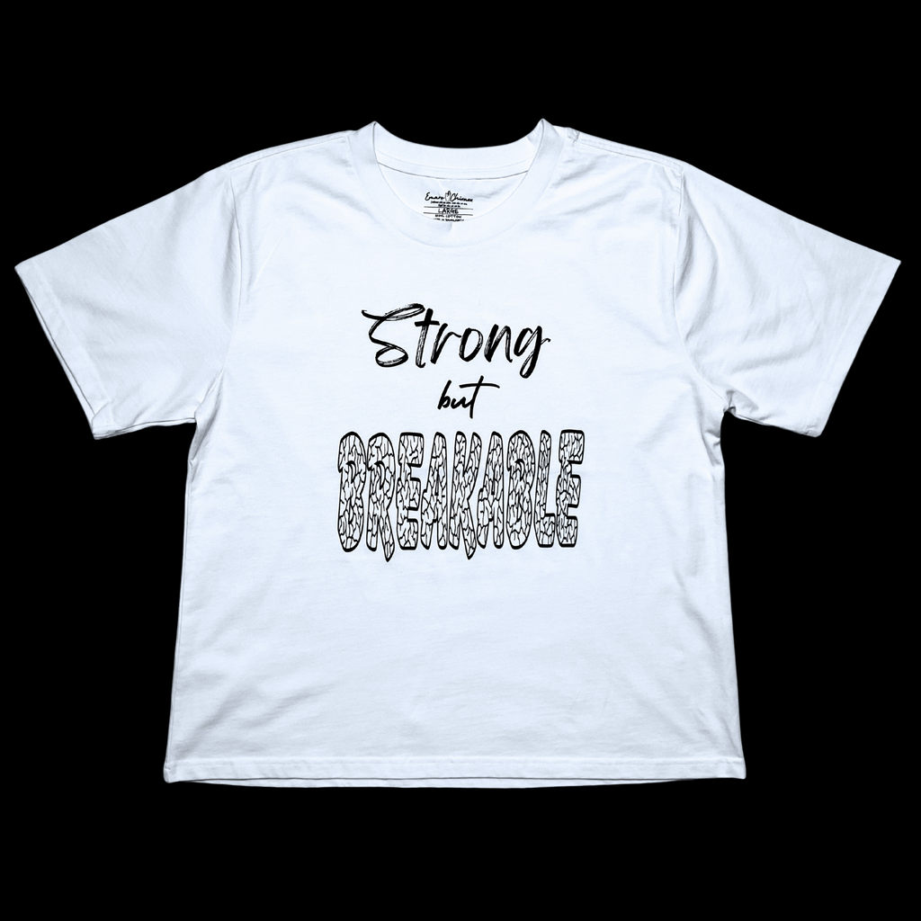 Front of white t-shirt with "Strong but Breakable" black text design on a black background