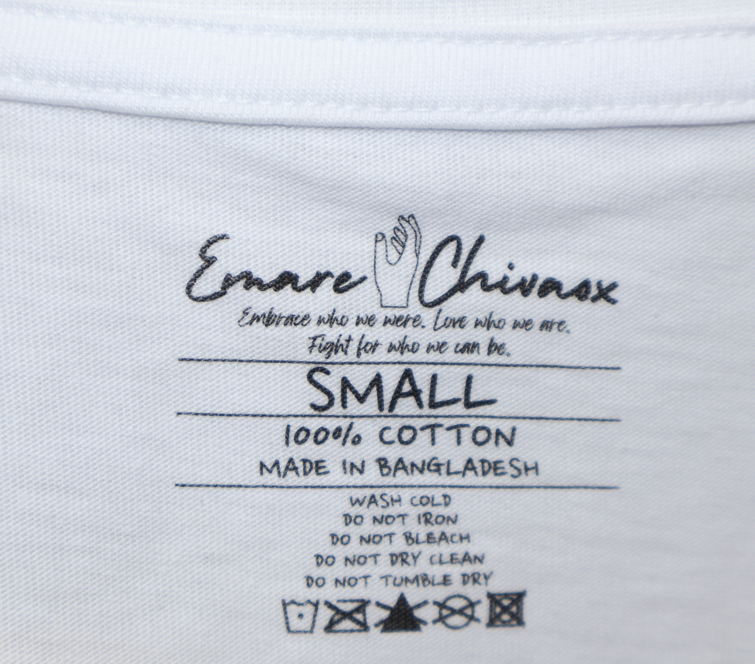 Custom next tag on a white t-shirt with black text featuring Emare Chivaox logo and slogan, shirt size, material, country of origin, and care instructions.
