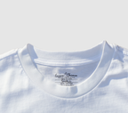 Zoomed in view of the front collar of a white t-shirt on a gray background.